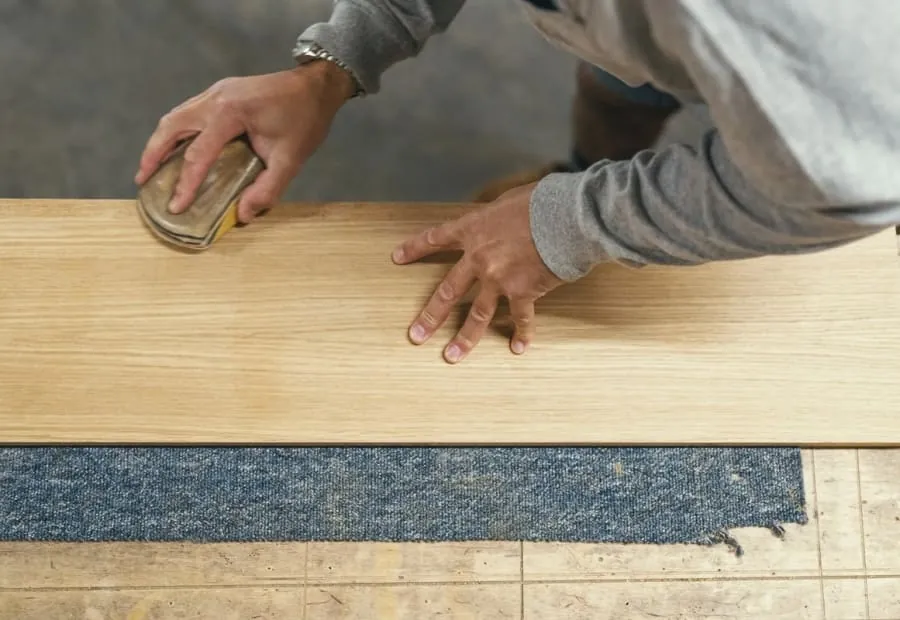 Hand finishing a timber panel in the workshop before it is delivered