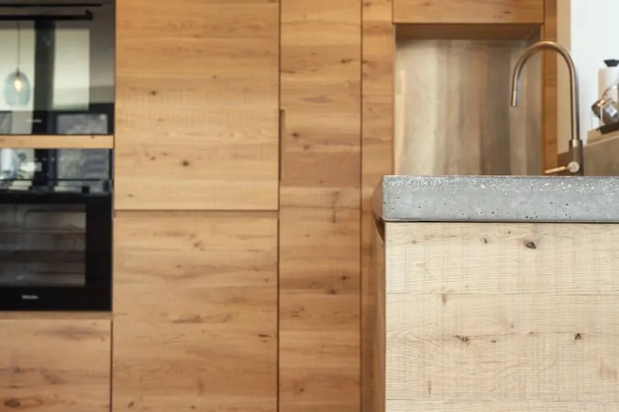 Full-height oak kitchen doors and a rough-sawn oak base with a grey stone worktop, made in our workshop, the kind of kitchen we design for homes in Maidencombe