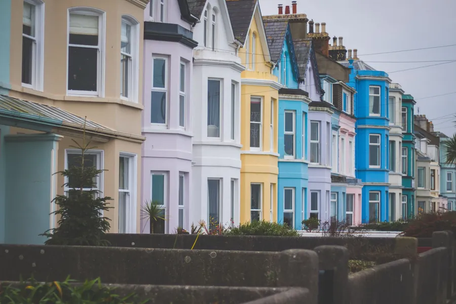 Row of painted bay-fronted Victorian terraced houses, the kind of period home in Torquay where a spare bedroom often becomes a walk-in wardrobe