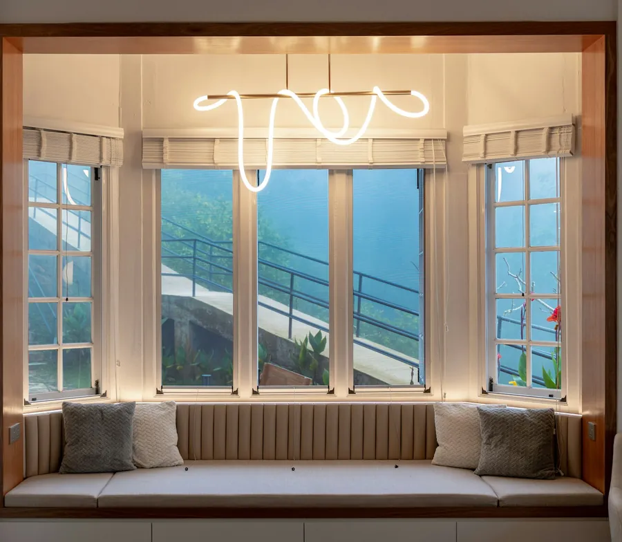 Upholstered window seat built into a deep bay with panelled sides, the kind of joinery that suits a Paignton villa
