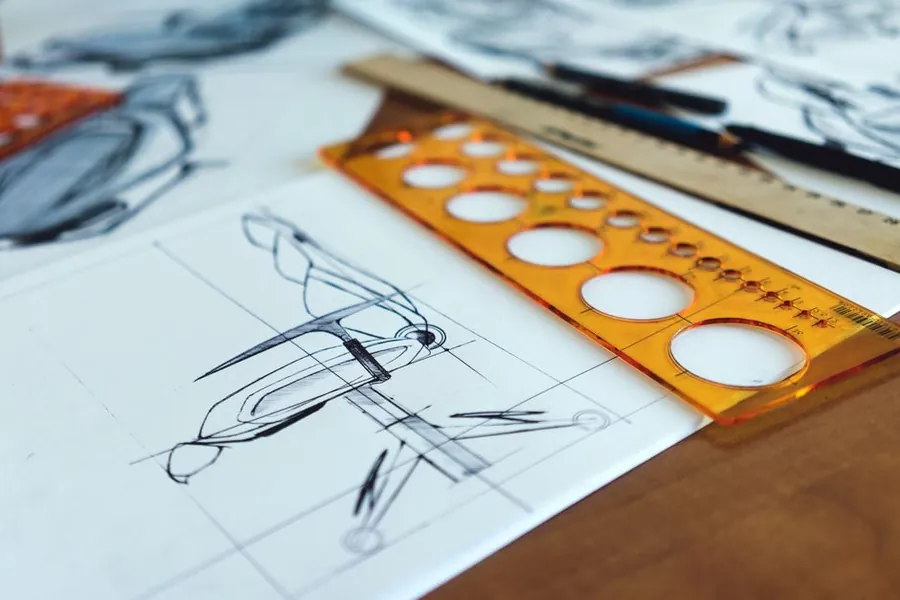 Scale drawings and drafting tools on a desk during the design approval stage of a joinery commission