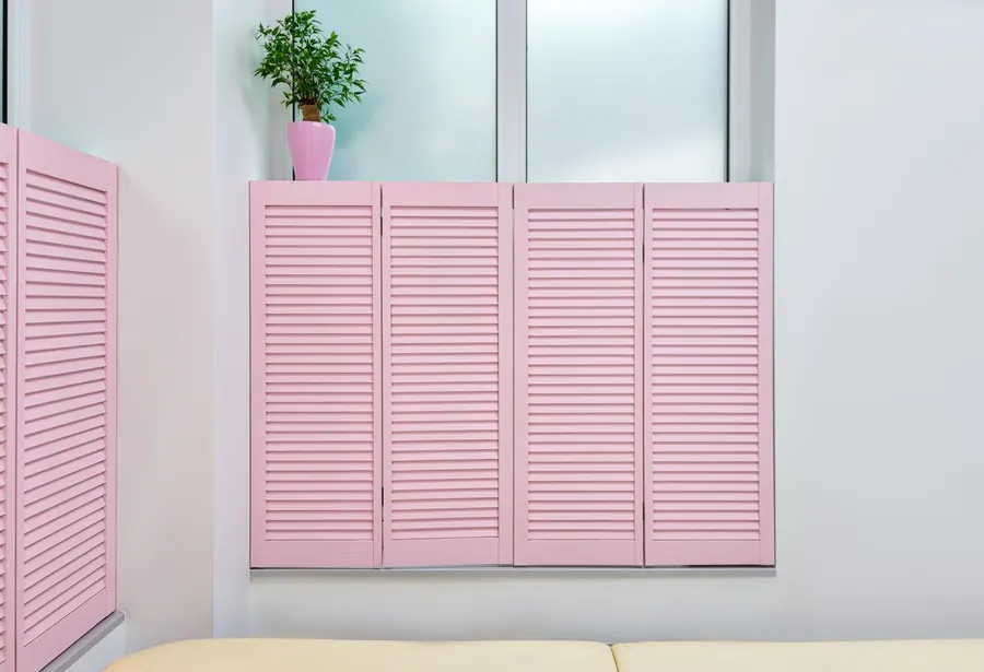 Painted louvred café-style shutters covering the lower half of a window with the upper glass left clear, a style we make for Torquay kitchens and bathrooms