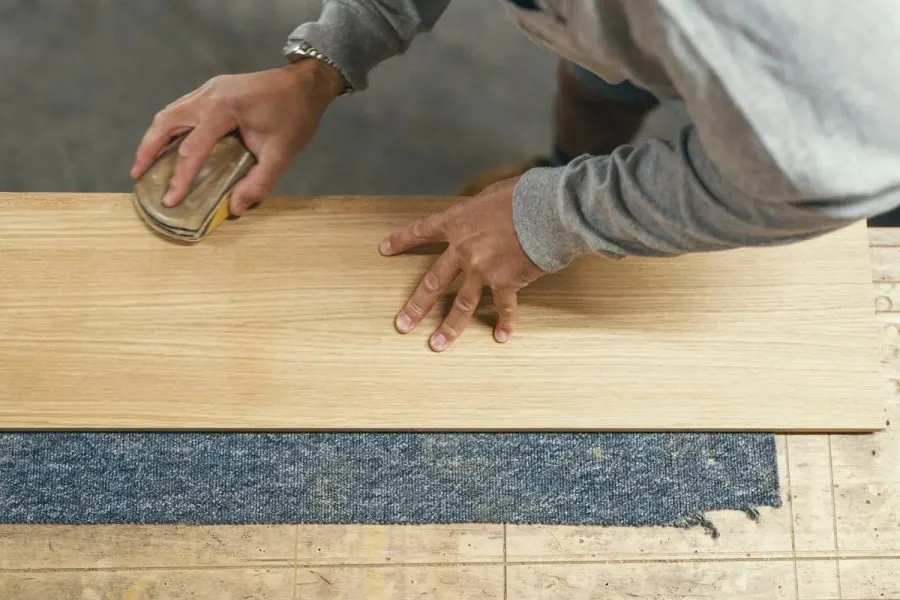 Hand-finishing a pale oak panel in our Torquay workshop before it becomes part of a commission