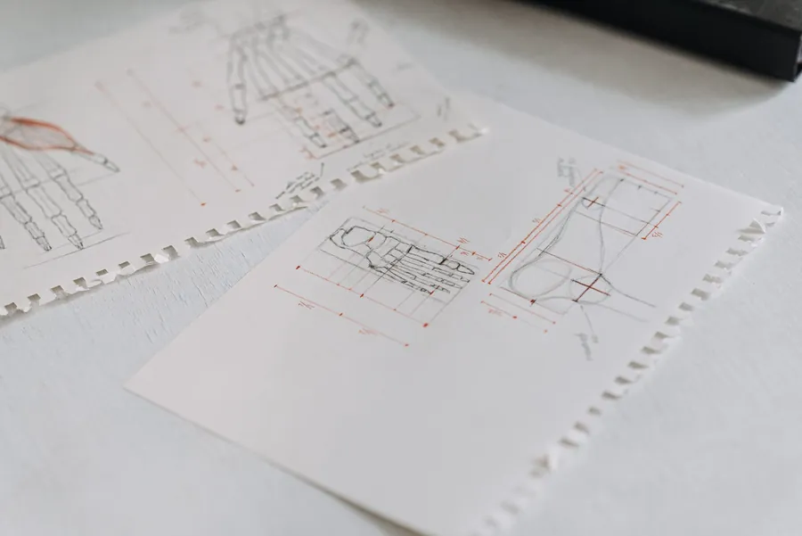 Pencil technical sketches with measured construction details on sheets of white paper