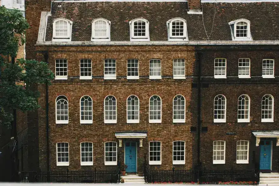 Georgian brick facade with sash windows and panelled front doors, the kind of listed building where internal joinery is also protected