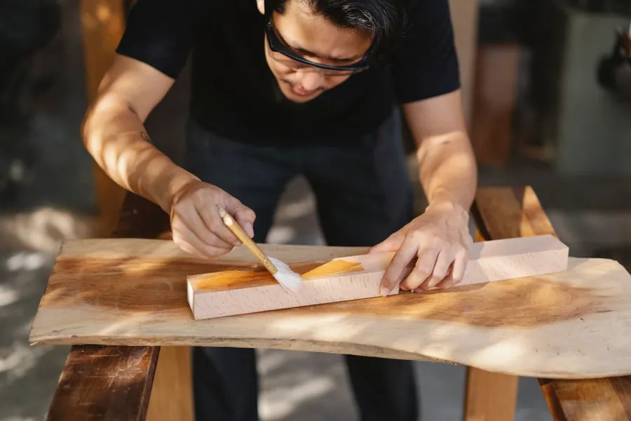 Applying a protective finish to a timber component in a joinery workshop