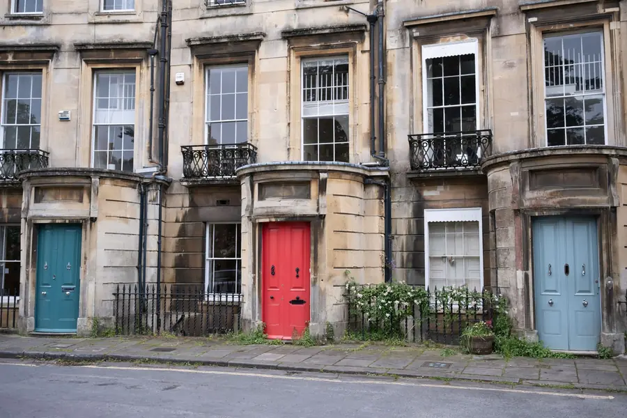 Row of painted Georgian terraced houses with sash windows and iron railings, the type of period street where conservation rules can affect joinery