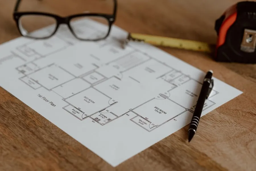 Floor plan drawings, glasses and a tape measure, the kind of detail a fitted home office quote should be based on