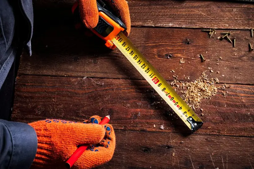 Measuring up with a tape during a joinery survey before drawings are produced