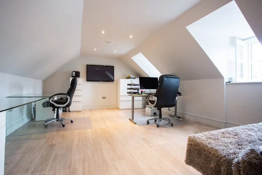 Loft conversion room with low knee walls under a sloping ceiling and roof windows, the eaves space where we build drawers and cupboards in Torquay homes