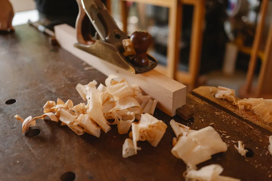 Hand plane and shavings on a joiner's bench as timber is prepared for under-stairs and eaves storage in our Torquay workshop