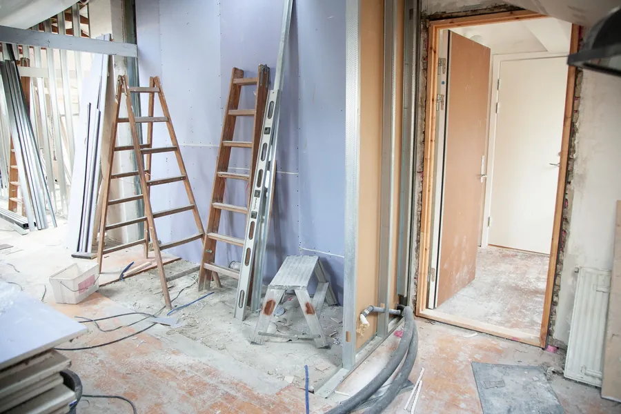 Room stripped back to brick with metal studs and plasterboard sheets ready, the construction method behind a builder's media wall in Torquay
