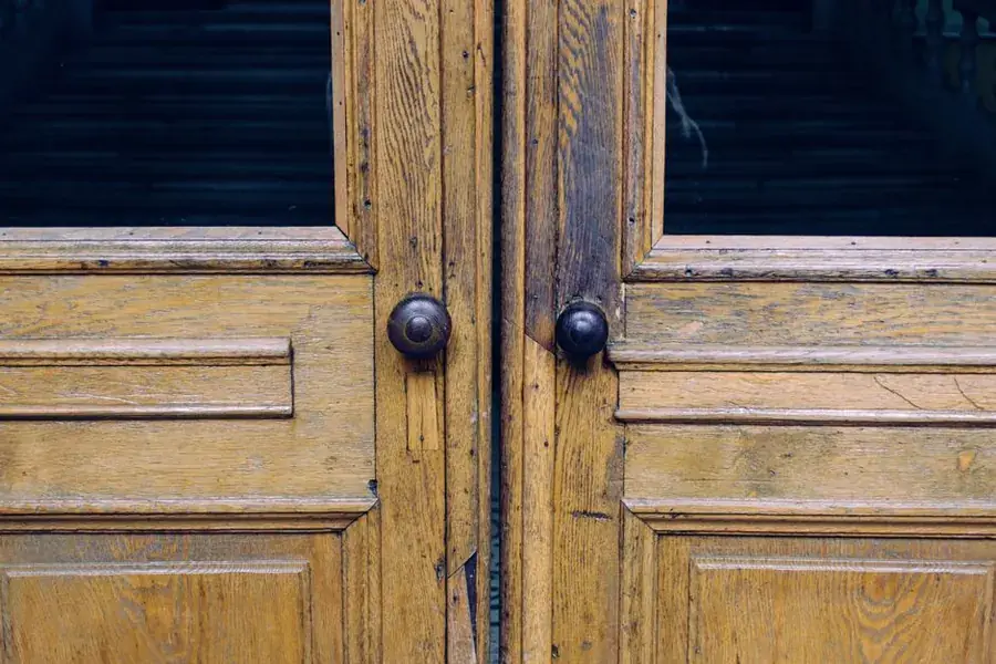 Original panelled timber doors with period ironmongery, showing the proportions a reproduction door usually misses
