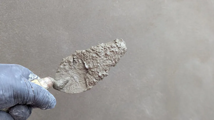 Plasterer's trowel and fresh plaster on a wall, the stage that must be finished before a joinery survey in Torquay