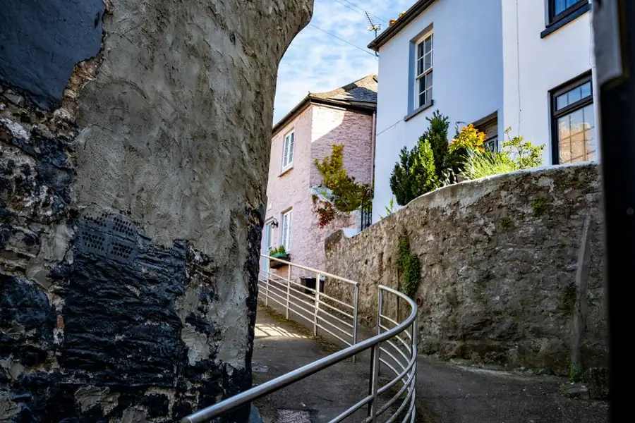 Sheltered narrow coastal street in Brixham, Torbay, where external timber joinery weathers far more slowly