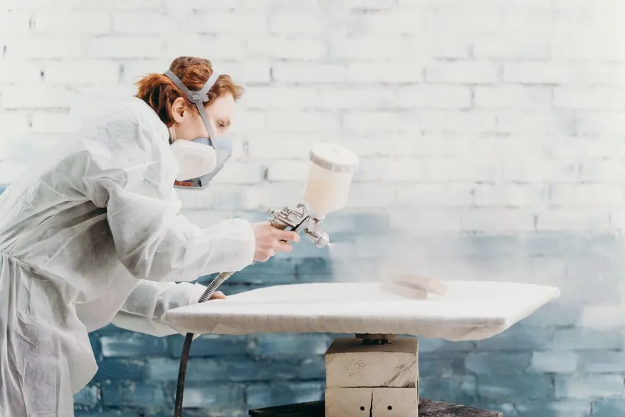 Spraying a furniture finish in a workshop, the process behind the flattest painted wardrobe doors