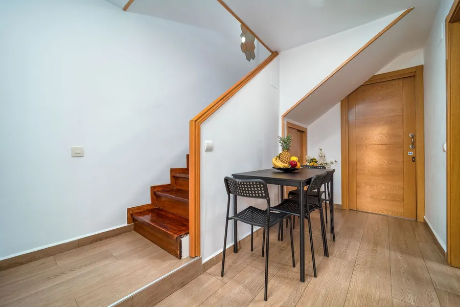 Steep timber staircase turning up between plain walls in a small house, similar to the tight stairs in Brixham cottages