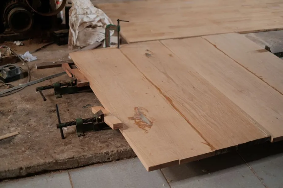 Clamped timber planks in a workshop, conditioning before machining begins