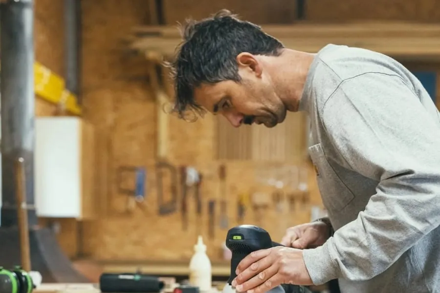 Joiner sanding a timber component at the bench in a Torquay workshop