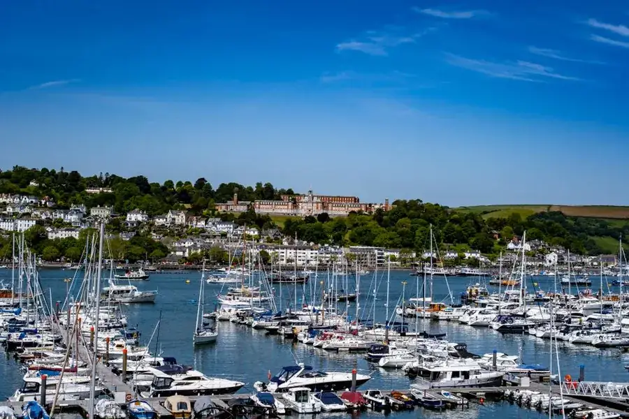 Boats moored in a South Devon harbour on a clear summer day, the season a Torbay holiday let fit-out has to be booked around