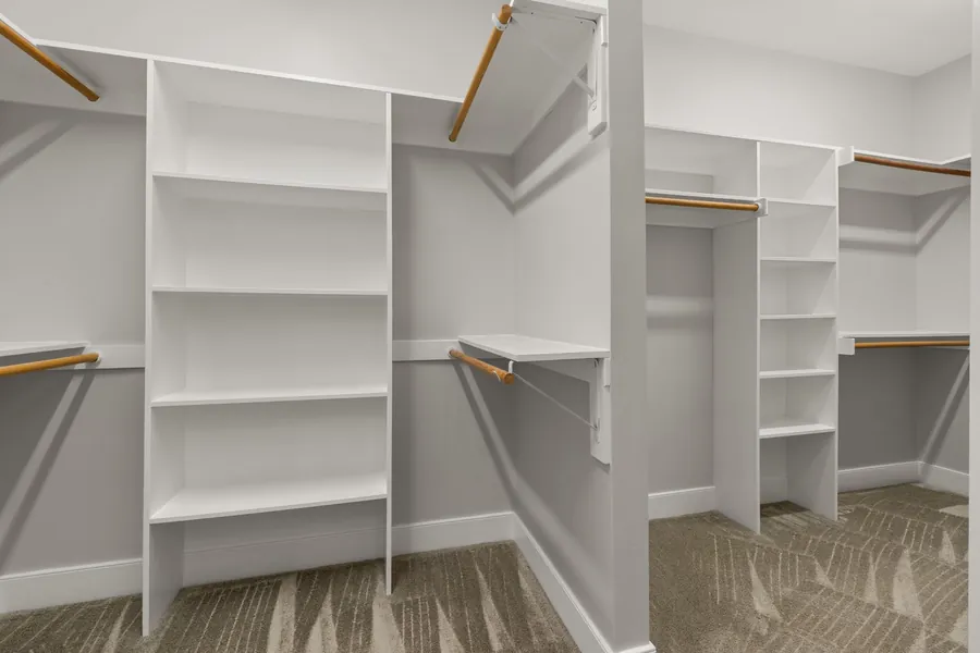 Empty U-shaped walk-in wardrobe with hanging rails and shelving towers on three sides, the layout that suits a squarer room in Torquay