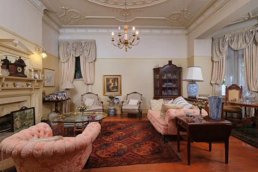 High-ceilinged period drawing room with ornate plaster ceiling and fireplace, the proportions a media wall has to suit in a Torquay villa