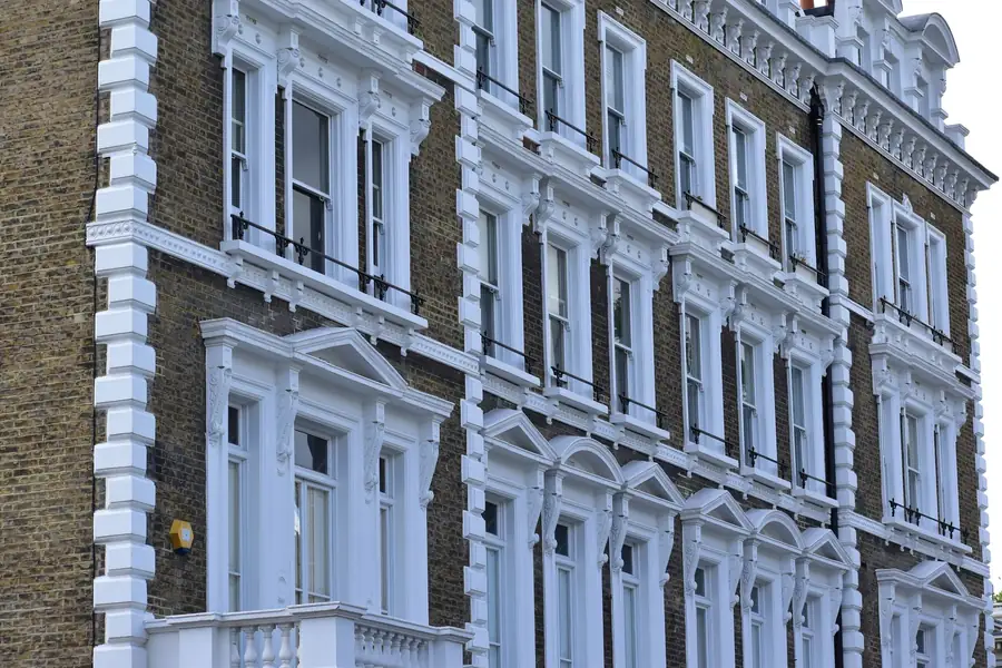Painted Victorian stucco frontage with rows of tall sash windows and moulded surrounds