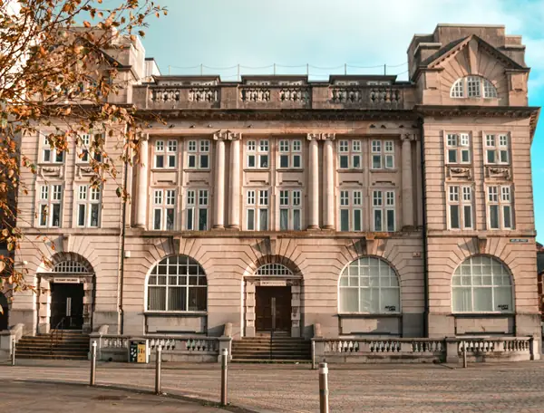 A period building with arched ground-floor windows and a pale stone front