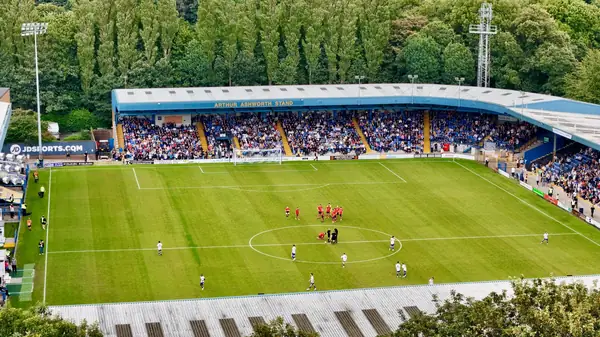 A football ground with covered stands and a green pitch, seen from above