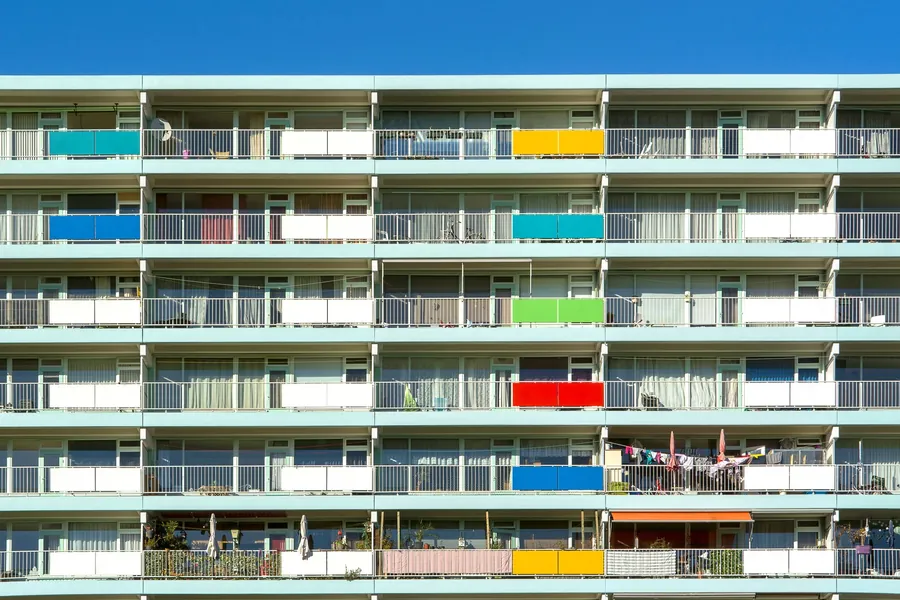 A block of flats with rows of balconies facing the light