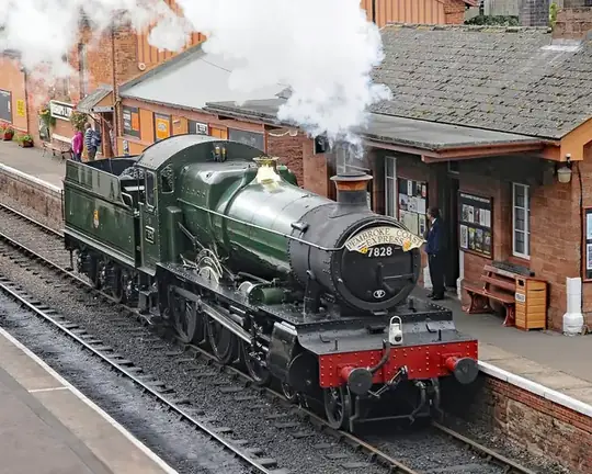 A steam locomotive standing at a heritage railway station platform