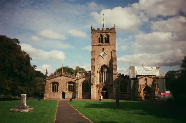 A church tower at the end of a path through the churchyard