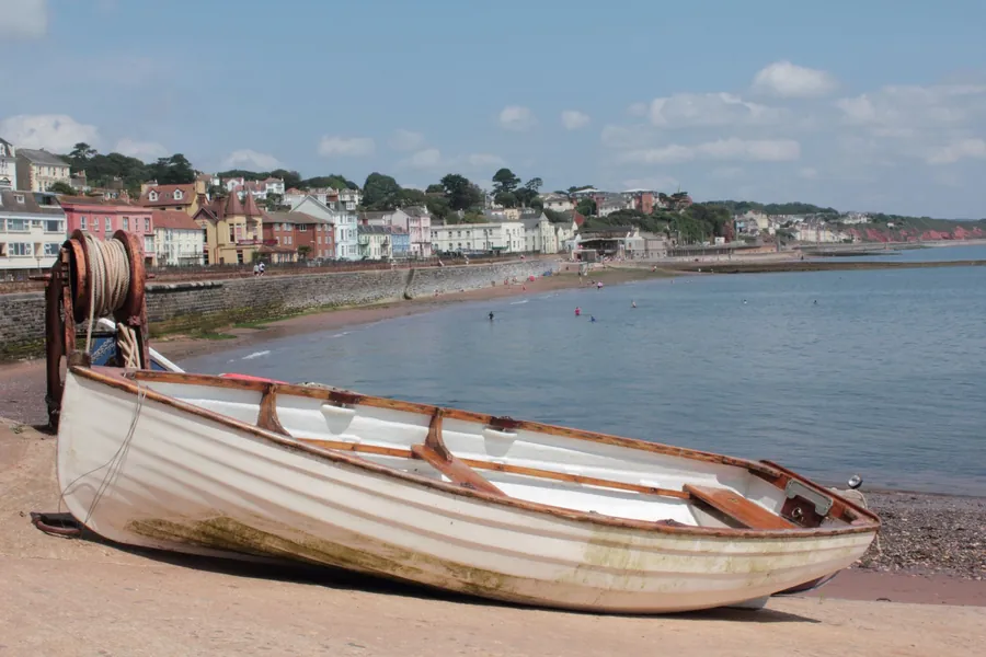 Seafront terraces beyond a sandy beach, with an old rowing boat in the foreground